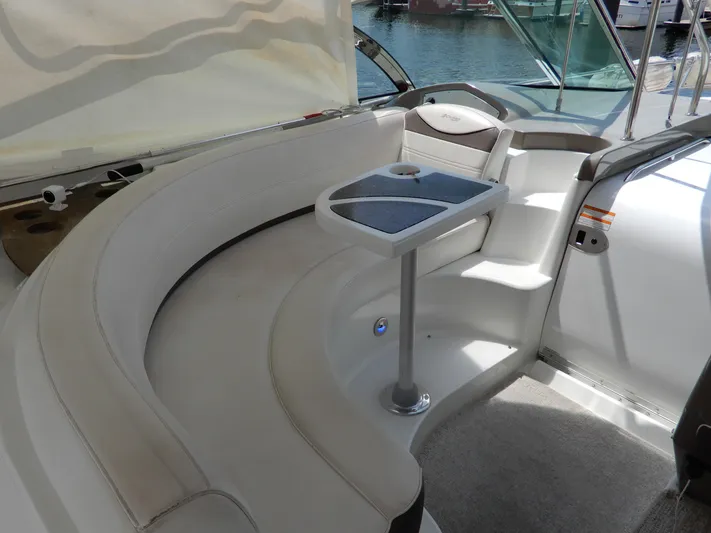  Yacht Photos Pics 2008 Cruisers Yachts 460 Express interior with curved seating and table, docked by the water.