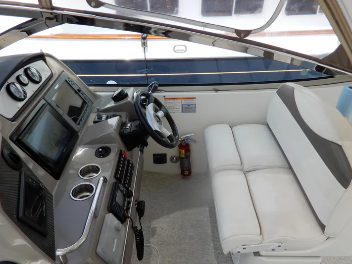  Yacht Photos Pics 2008 Cruisers Yachts 460 Express helm with steering wheel, controls, and white seating.