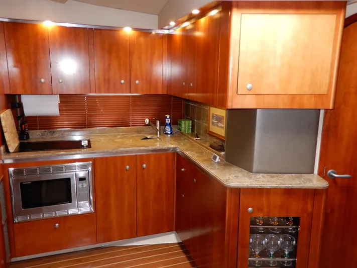  Yacht Photos Pics Luxurious wooden kitchen interior of 2008 Cruisers Yachts 460 Express with modern appliances.