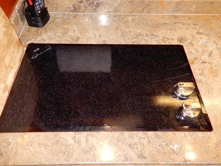  Yacht Photos Pics Ceramic cooktop with two knobs on a marble countertop in a 2008 Cruisers Yachts 460 Express.