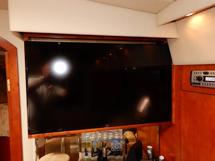  Yacht Photos Pics Flat-screen TV in 2008 Cruisers Yachts 460 Express interior, with wooden paneling and control panel.