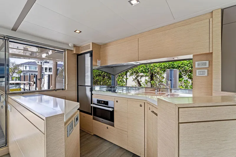 Blue Abalone Yacht Photos Pics Modern kitchen interior of 2015 Ferretti Yachts 690, featuring sleek cabinetry and appliances.