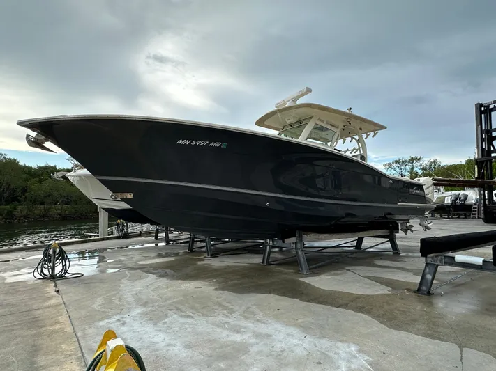  Yacht Photos Pics 2017 Scout 350 LXF boat on dock, sleek black hull, overcast sky.