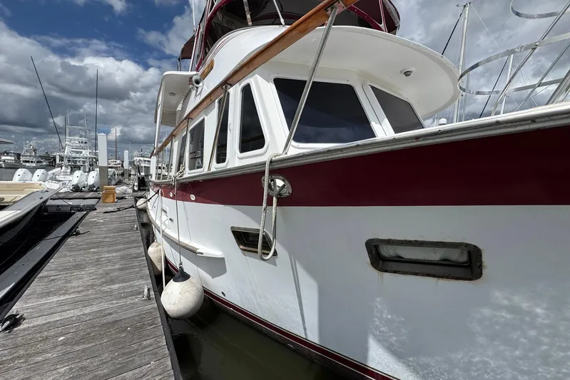 The Smithsunian Yacht Photos Pics 1989 DeFever 49 CPMY yacht docked at marina under cloudy sky.