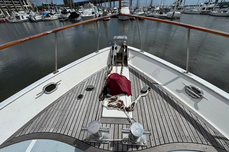 The Smithsunian Yacht Photos Pics 1989 DeFever 49 CPMY yacht bow with marina view, featuring wooden deck and anchor chain.