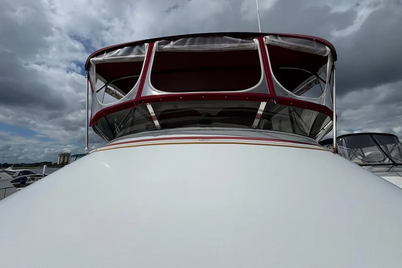 The Smithsunian Yacht Photos Pics 1989 DeFever 49 CPMY yacht with red canopy under cloudy sky.