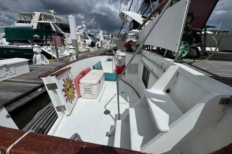 The Smithsunian Yacht Photos Pics 1989 DeFever 49 CPMY yacht docked, featuring a sun-themed design and seating area.