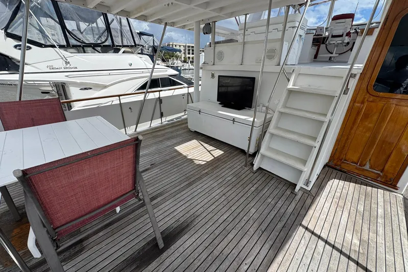 The Smithsunian Yacht Photos Pics 1989 DeFever 49 CPMY yacht deck with seating, stairs, and marina view.