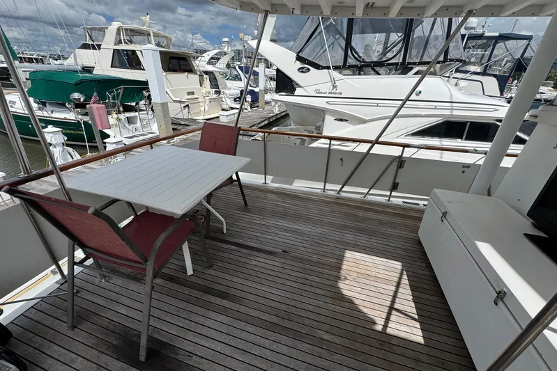 The Smithsunian Yacht Photos Pics Outdoor seating on 1989 DeFever 49 CPMY yacht, docked at marina with other boats.