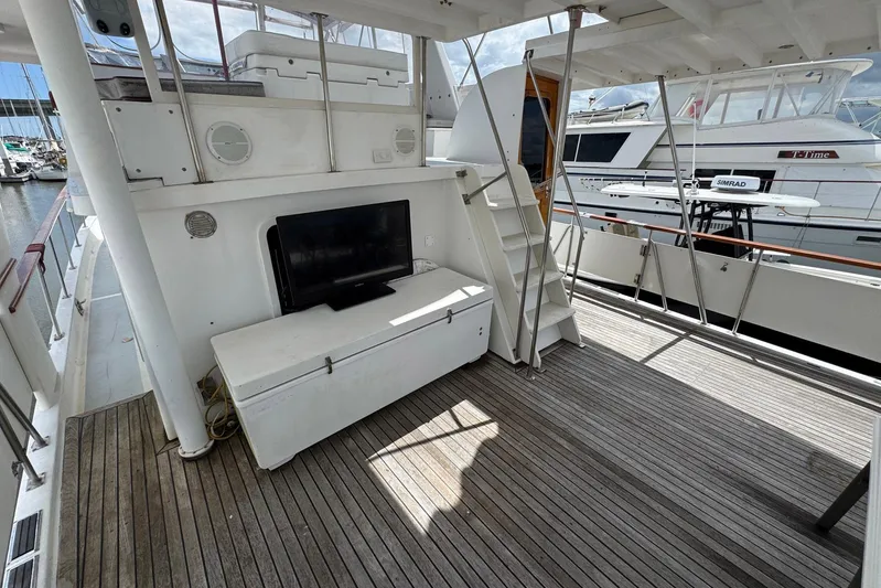 The Smithsunian Yacht Photos Pics 1989 DeFever 49 CPMY yacht deck with TV, wooden flooring, and stairs.