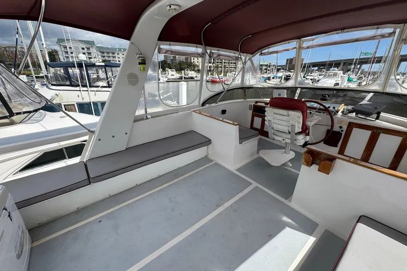 The Smithsunian Yacht Photos Pics 1989 DeFever 49 CPMY yacht cockpit with seating and helm, docked at marina.
