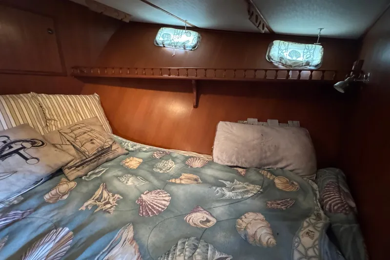 The Smithsunian Yacht Photos Pics Cozy cabin interior of 1989 DeFever 49 CPMY with nautical-themed bedding.