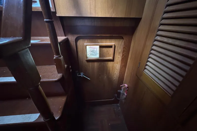 The Smithsunian Yacht Photos Pics Interior of 1989 DeFever 49 CPMY yacht, featuring wooden stairs and door.