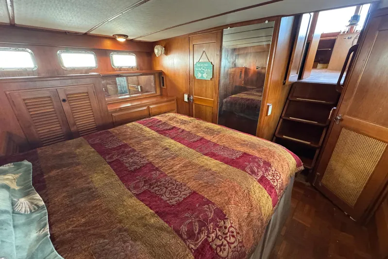The Smithsunian Yacht Photos Pics Cozy bedroom in 1989 DeFever 49 CPMY yacht with wood paneling and colorful bedding.