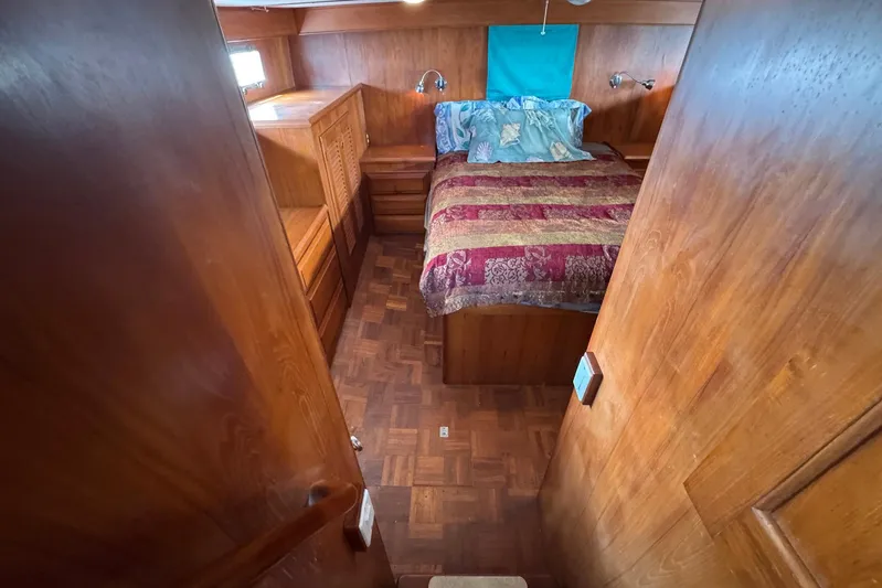 The Smithsunian Yacht Photos Pics Cozy bedroom in 1989 DeFever 49 CPMY yacht with wood paneling and colorful bedding.