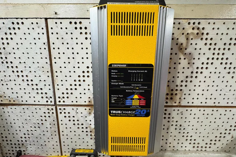 The Smithsunian Yacht Photos Pics Yellow Truecharge 20+ multi-stage battery charger mounted on perforated wall.