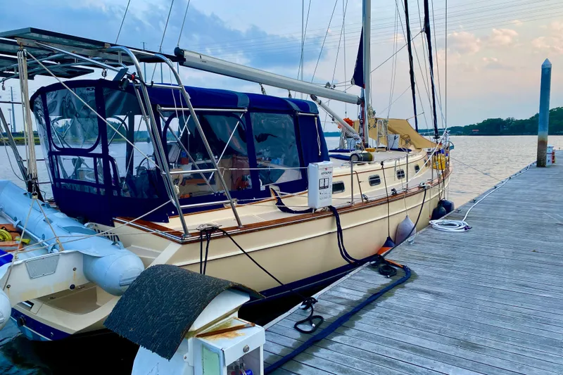 Second Wind Yacht Photos Pics 2006 Island Packet 440 sailboat docked at a marina, featuring a blue canopy.