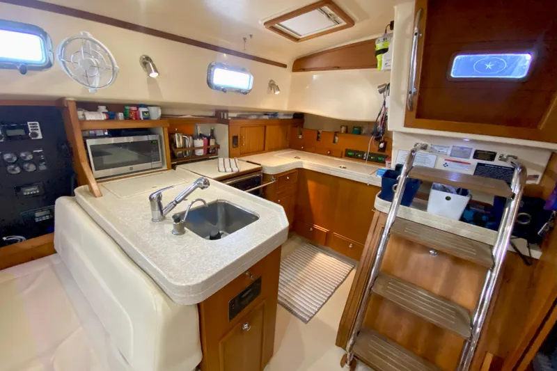 Second Wind Yacht Photos Pics Interior of 2006 Island Packet 440 yacht, featuring a modern kitchen with wooden cabinetry.
