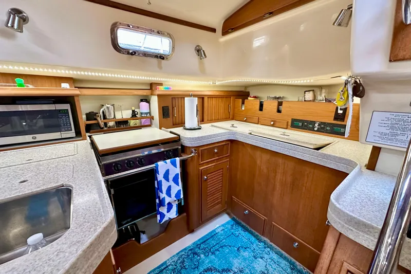 Second Wind Yacht Photos Pics Luxurious 2006 Island Packet 440 yacht kitchen with modern appliances and elegant wood cabinetry.