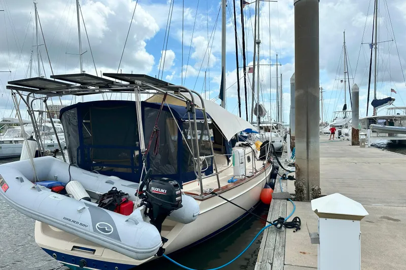 Second Wind Yacht Photos Pics Island Packet 440 sailboat docked at marina, featuring solar panels and inflatable dinghy.