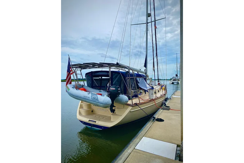 Second Wind Yacht Photos Pics Sailboat Island Packet 440, 2006 model, docked with dinghy and American flag.