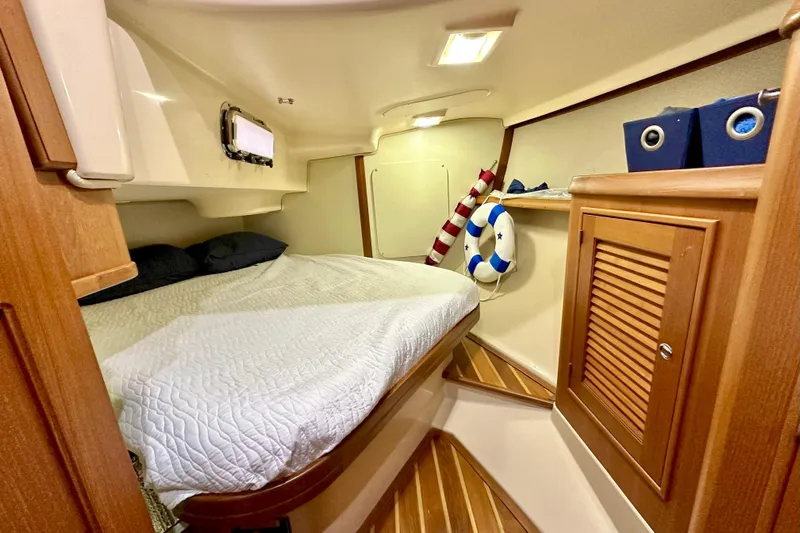 Second Wind Yacht Photos Pics Cozy cabin interior of 2006 Island Packet 440 sailboat with bed and nautical decor.