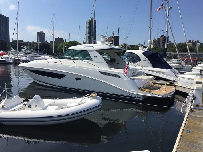  Yacht Photos Pics 2013 Sea Ray 450 Sundancer yacht docked in a marina with city skyline.