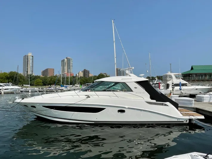 Yacht Photos Pics 2013 Sea Ray 450 Sundancer yacht docked in marina with city skyline background.