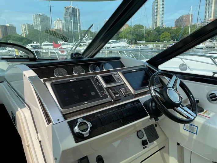  Yacht Photos Pics Helm of 2013 Sea Ray 450 Sundancer with modern controls and cityscape background.