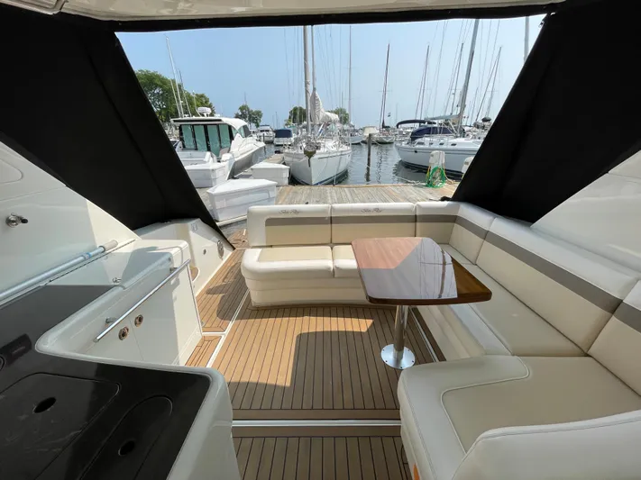  Yacht Photos Pics 2013 Sea Ray 450 Sundancer yacht interior with seating and table, docked at marina.
