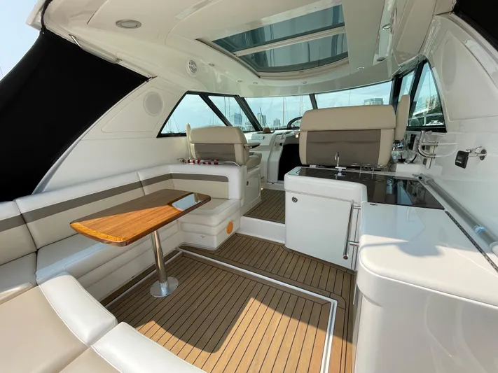  Yacht Photos Pics Interior of 2013 Sea Ray 450 Sundancer yacht with seating and wooden table.
