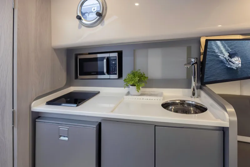  Yacht Photos Pics Modern kitchenette in 2025 Hanover 387 yacht with microwave, sink, and cooktop.