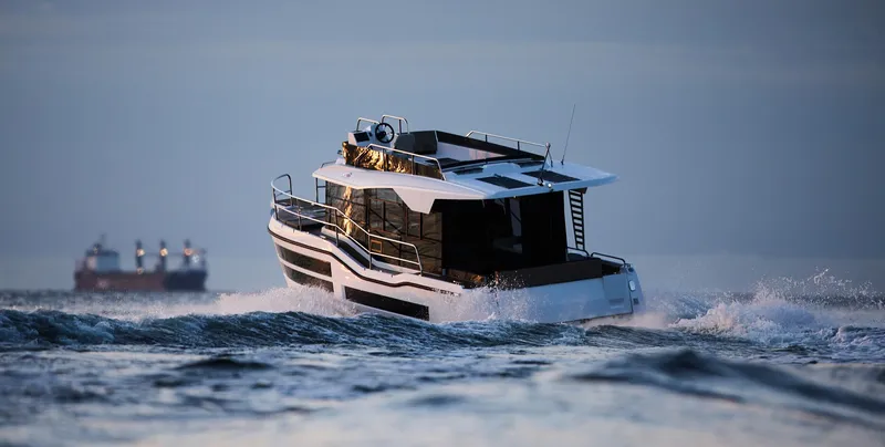  Yacht Photos Pics Northman 1050 boat cruising on open water, 2025 model, with distant ships in background.
