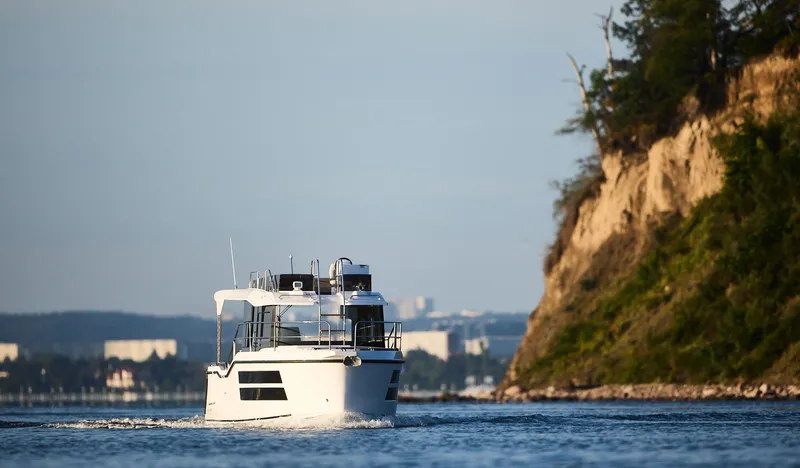  Yacht Photos Pics Northman 1050 boat cruising near a rocky coastline, 2025 model.