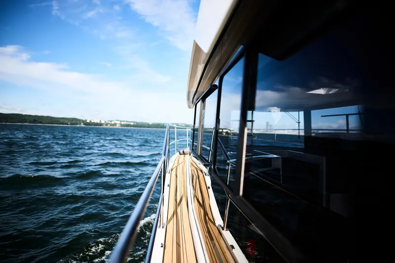  Yacht Photos Pics 2025 Northman 1050 yacht cruising on open water under a clear blue sky.