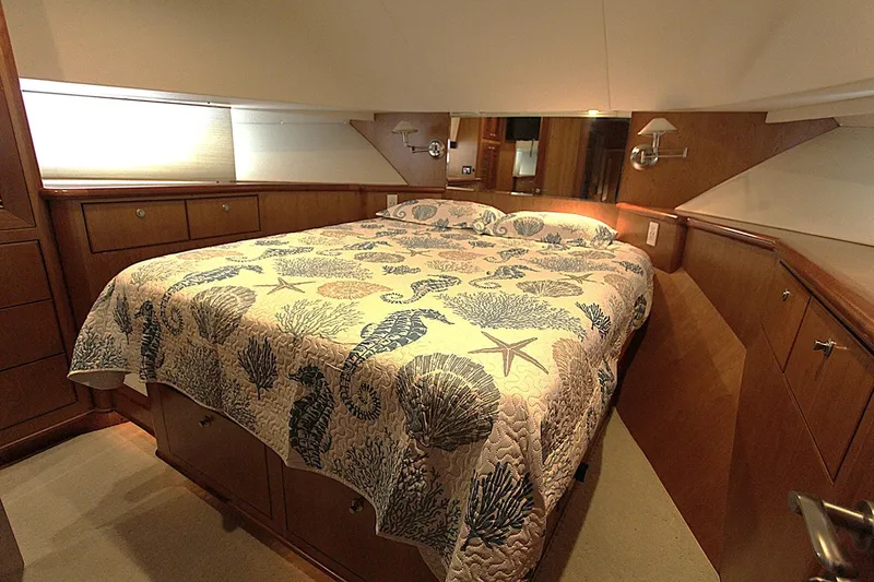 No Name Yacht Photos Pics Luxurious bedroom in 2001 Symbol 62 Pilothouse yacht with nautical-themed bedding.