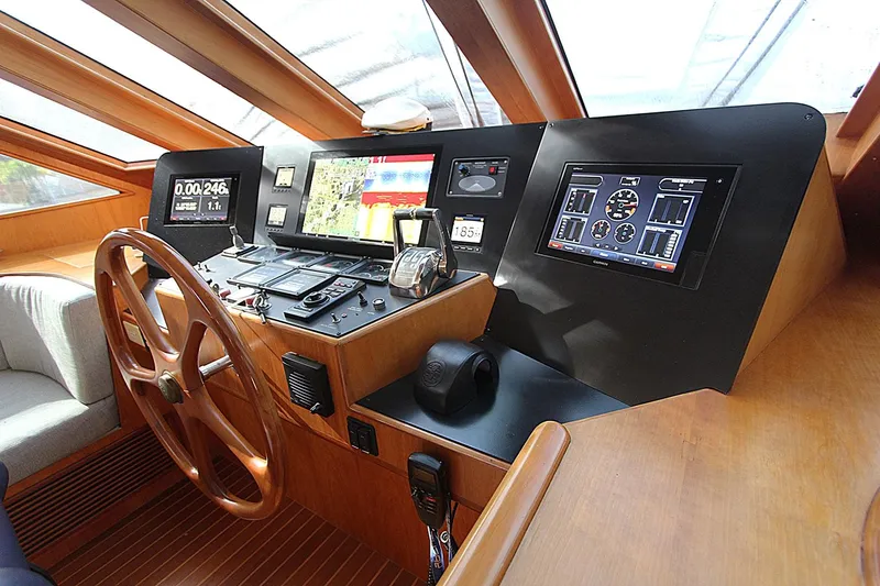No Name Yacht Photos Pics Pilothouse interior of 2001 Symbol 62, featuring wooden steering wheel and modern navigation equipment.