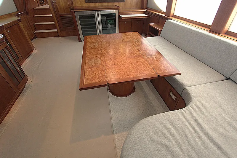 No Name Yacht Photos Pics Luxurious interior of 2001 Symbol 62 Pilothouse yacht with wooden table and plush seating.