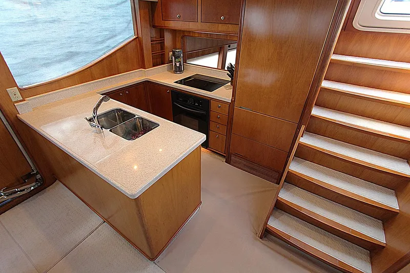 No Name Yacht Photos Pics Luxurious 2001 Symbol 62 Pilothouse kitchen with wood cabinetry and modern appliances.