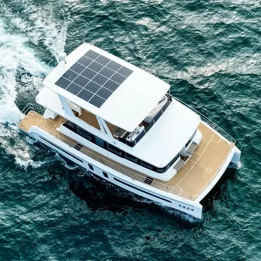  Yacht Photos Pics Aerial view of 2025 Mazarin 55 Catamaran with solar panels cruising on the ocean.