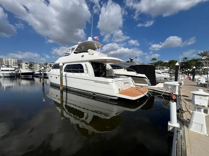 Roweboat Yacht Photos Pics 2006 Carver Voyager yacht docked at marina under blue sky with clouds.