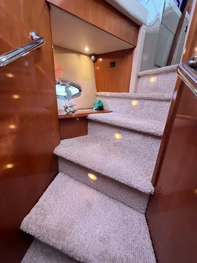 Roweboat Yacht Photos Pics Interior stairs of 2006 Carver Voyager Sky Lounge yacht with carpet and wood finish.