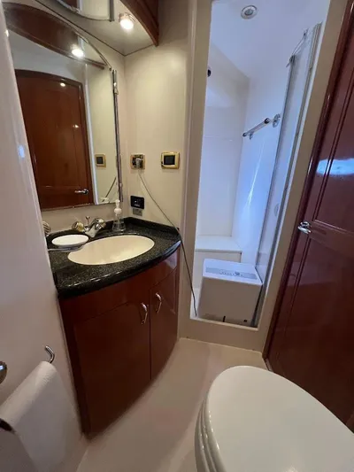 Roweboat Yacht Photos Pics 2006 Carver Voyager Sky Lounge bathroom with modern fixtures and wood cabinetry.