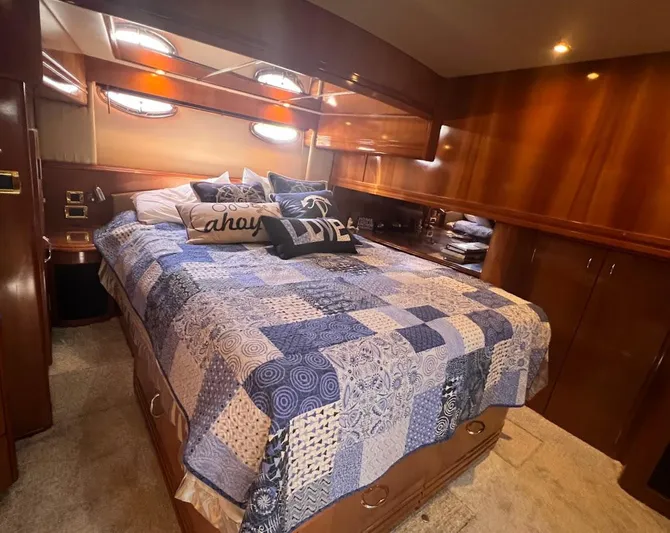 Roweboat Yacht Photos Pics Luxurious bedroom in 2006 Carver Voyager Sky Lounge yacht with cozy bedding and wood paneling.