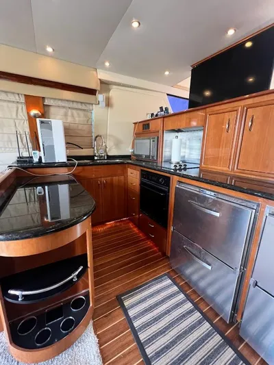 Roweboat Yacht Photos Pics 2006 Carver Voyager Sky Lounge kitchen with modern appliances and sleek wooden cabinetry.