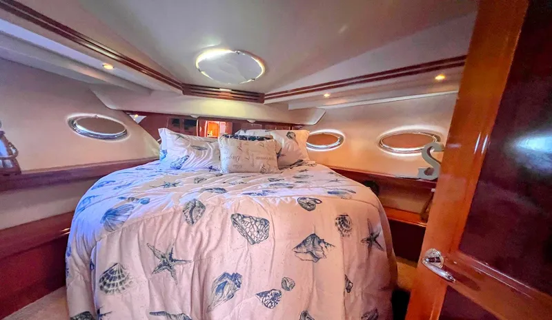 Roweboat Yacht Photos Pics Luxurious bedroom in 2006 Carver Voyager Sky Lounge yacht with nautical-themed bedding.