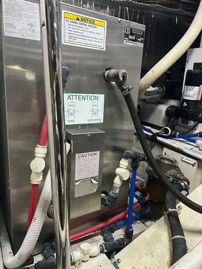 Roweboat Yacht Photos Pics Engine room of a 2006 Carver Voyager with various pipes and warning labels.