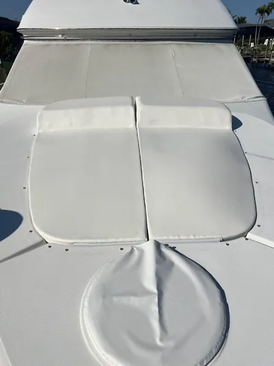 Roweboat Yacht Photos Pics 2006 Carver Voyager yacht with white sunbathing cushions on deck.