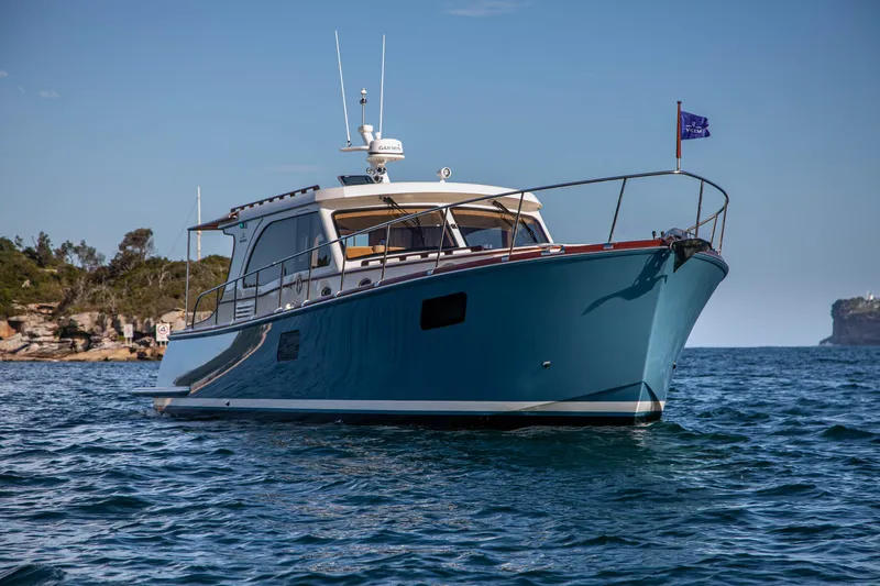 Mareluna Yacht Photos Pics 2023 Vicem 55 yacht on calm water, clear sky, coastal background.