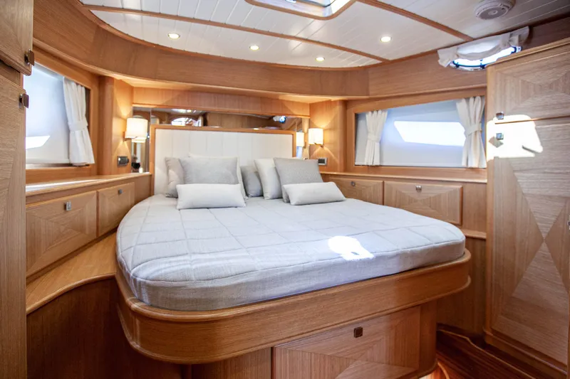 Mareluna Yacht Photos Pics Luxurious cabin interior of 2023 Vicem 55 yacht with elegant wood finish and cozy bedding.